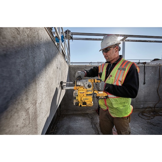 Brushless, cordless SDS PLUS L-shape rotary hammer being used by a person
