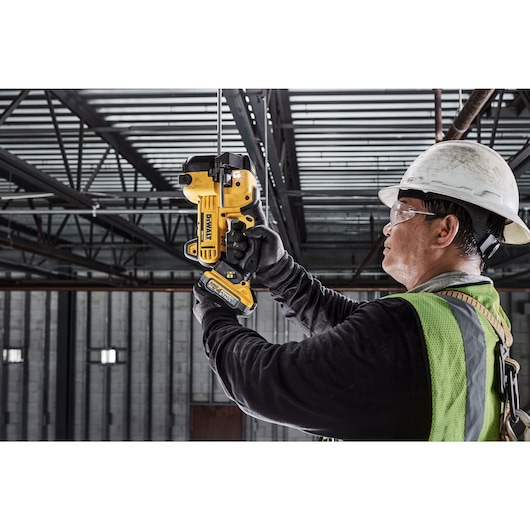 DEWALT Threaded Rod Cutter is being used to cut threaded rod overhead by tradesman in a data center.