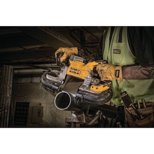 Close up of 5 inch Dual Switch Band Saw being used by worker to cut metal pipe