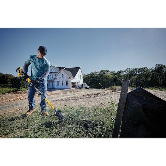 Cordless String Trimmer being used by a person.