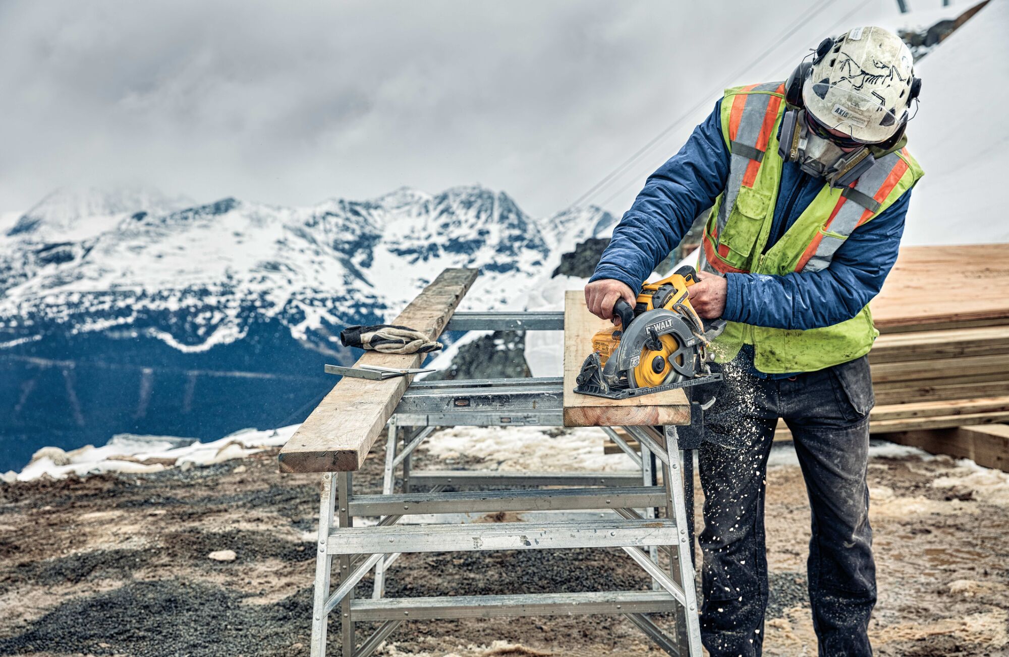 Close up of FLEXVOLT cordless worm drive style saw being used by person to cut wooden plank outdoors. Close up of FLEXVOLT cordless worm drive style saw being used by person to cut wooden plank outdoors.