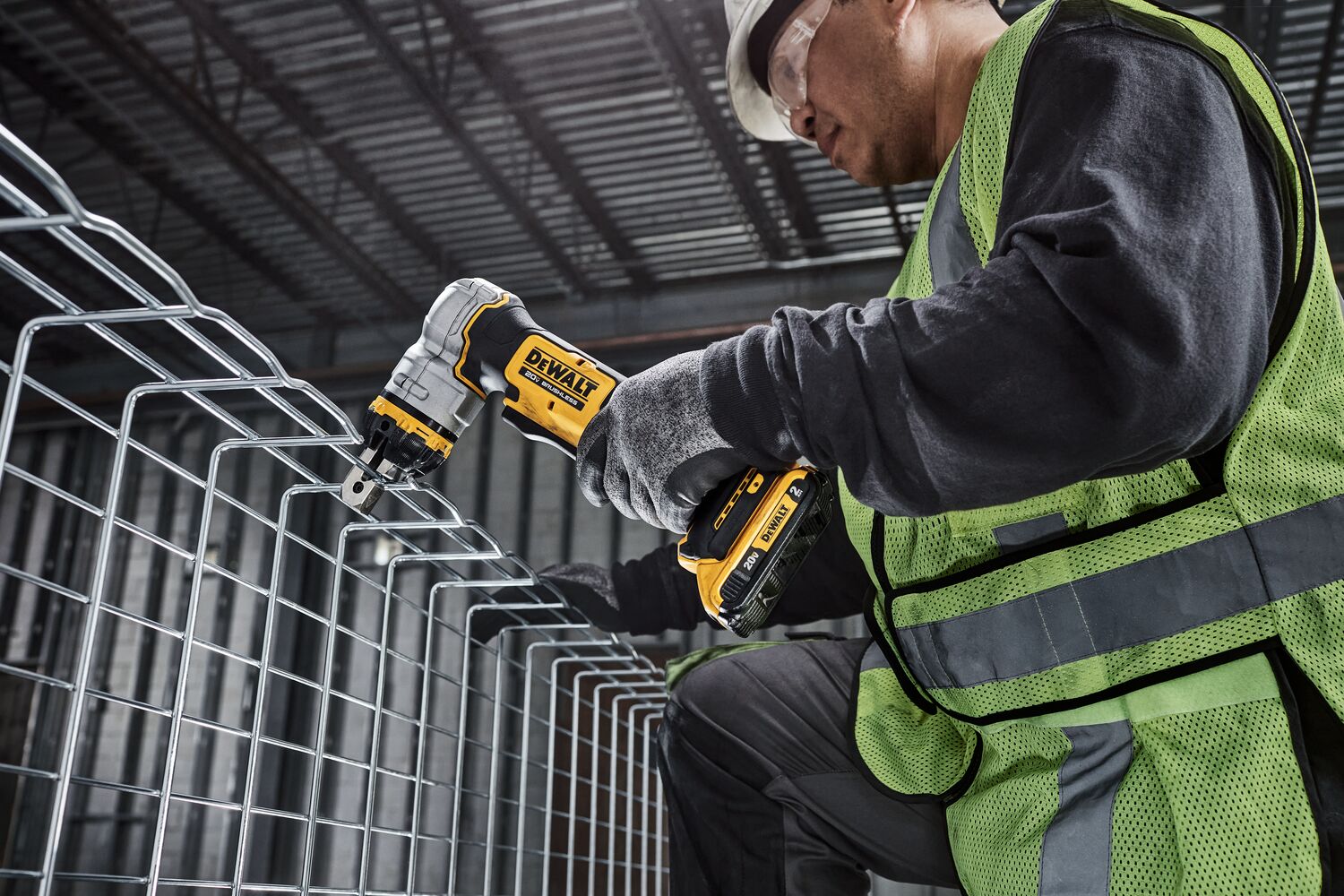 DEWALT Cable Tray Cutter is used by a kneeling tradesman to cut basket tray in a data center. DEWALT Cable Tray Cutter is used by a kneeling tradesman to cut basket tray in a data center.