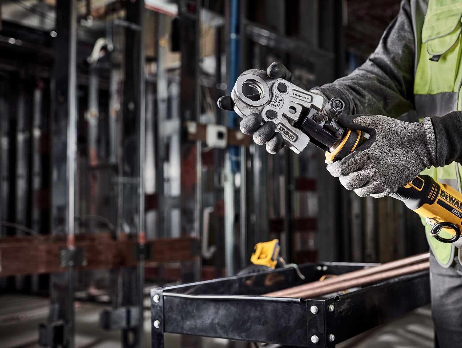 Tradesman is switching the jaw on the DEWALT Compact Press Tool in a mechanical room. Tradesman is switching the jaw on the DEWALT Compact Press Tool in a mechanical room.