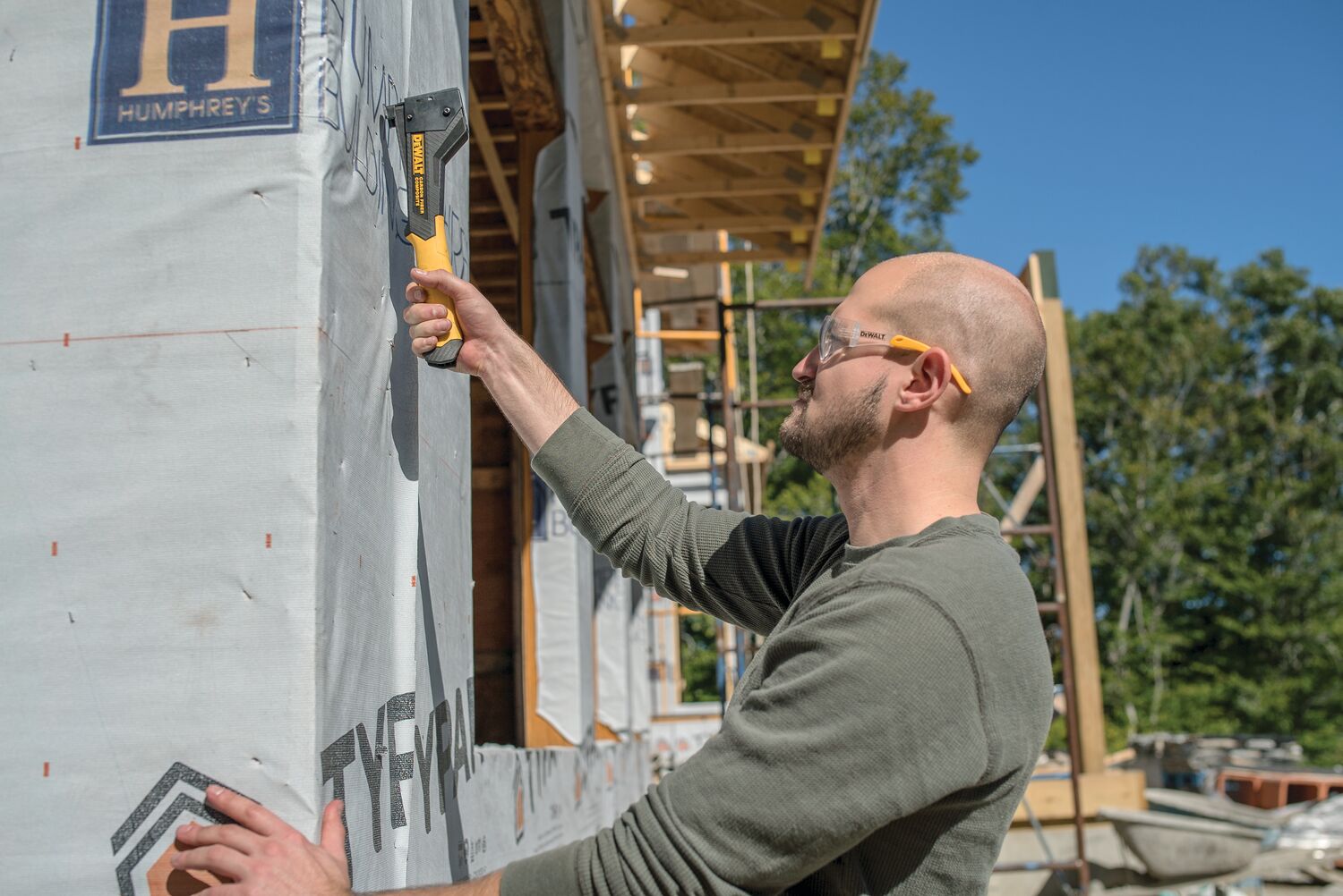 Carbon Fiber Composite Hammer Tacker being used on a construction site by a person. Carbon Fiber Composite Hammer Tacker being used on a construction site by a person.