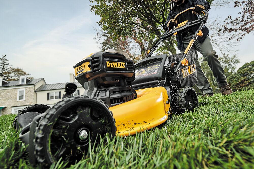 brushless cordless push mower being used by a person to mow a lawn brushless cordless push mower being used by a person to mow a lawn