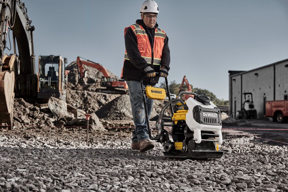 Man running plate compactor