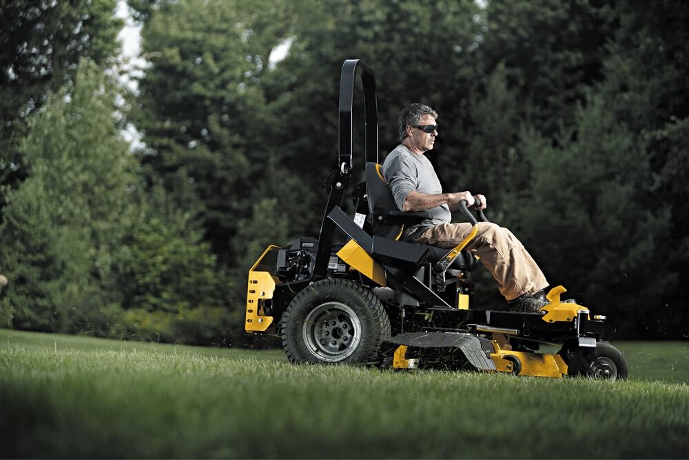 54 inch Kawasaki Gas Hydrostatic Commercial Zero Turn Mower being used by person to trim grass outdoors. 54 inch Kawasaki Gas Hydrostatic Commercial Zero Turn Mower being used by person to trim grass outdoors.