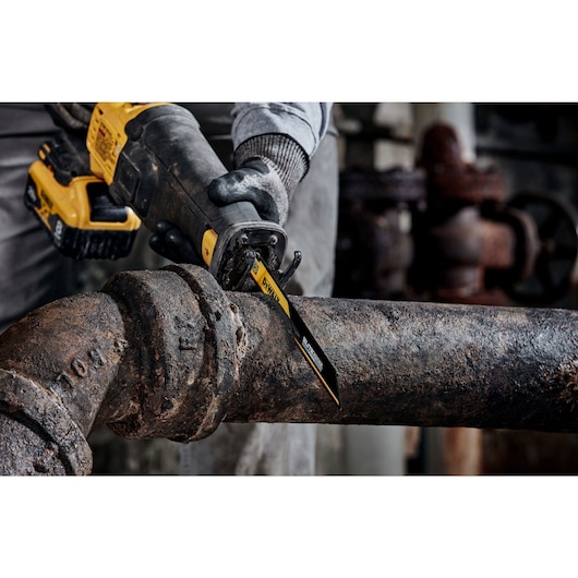 Person using ELITE SERIES Carbide Tipped Reciprocating Blade to cut pipe