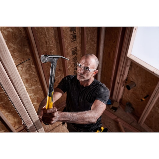 XP 1 Piece Steel 14 ounce MIG Weld Framing Hammer being used by a person on nail in wood.