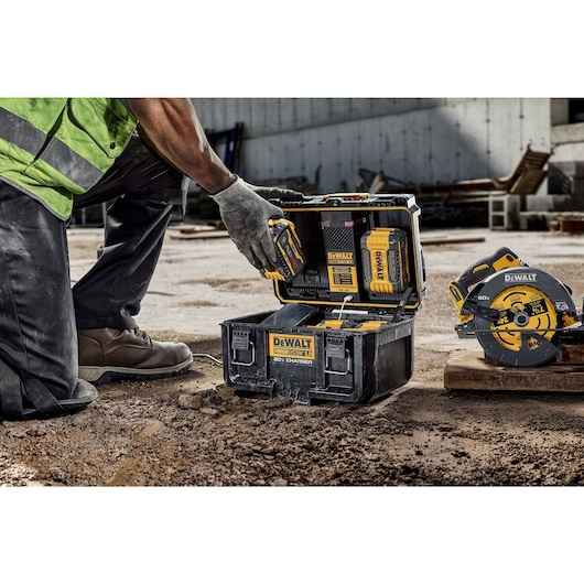 TS 2.0 DUAL CHARGER FRONT FACING IMAGE WITH MAN PLACING A BATTERY INSIDE THE CHARGER