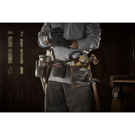 CONSTRUCTION PRO WEARING DEWALT LEATHER TOOL APRON
