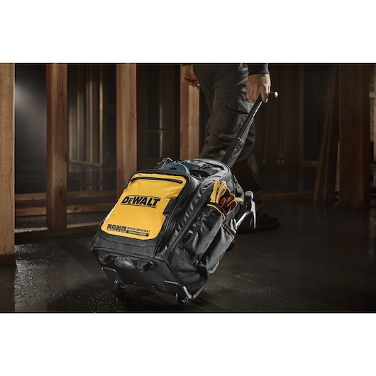 WORKER PULLING DEWALT PROFESSIONAL BACKPACK WITH WHEELS
