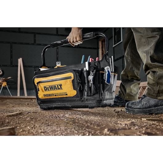 CONSTRUCTION WORKER HOLDING DEWALT 20 INCH PRO TOTE 