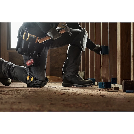 CONSTRUCTION PRO WEARING DEWALT HARD SHELL KNEE PADS WITH GEL