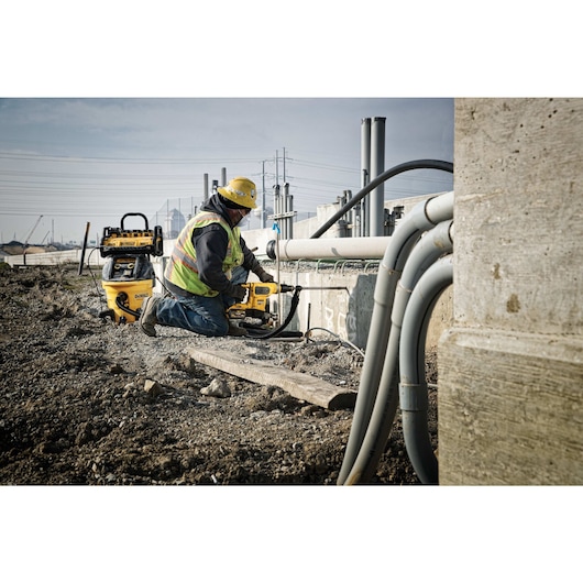 10 Gallon wet /  dry H E P A / R R P dust extractor being used by a person for fine particulate pick up like concrete.