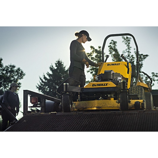 48 inch Kawasaki Gas Hydrostatic Commercial Hydro Walk Mower being used by person to mow grass outdoors.